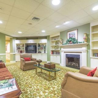 A cozy living room featuring a fireplace, comfortable seating, and built-in bookshelves.