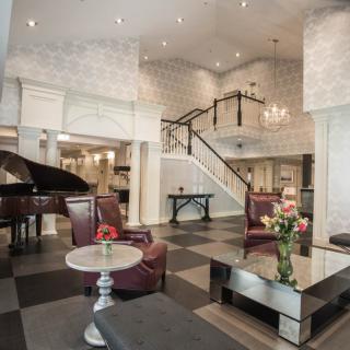 Elegant hotel lobby with a grand piano and stylish furnishings.