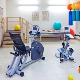 A well-equipped gym with stationary bikes and fitness balls for exercise and rehabilitation.