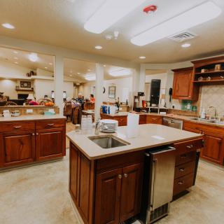 A spacious kitchen with a central island and wooden cabinets.