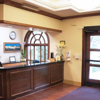 A welcoming reception area featuring a wooden front desk and elegant decor.