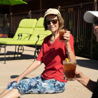 Two people enjoying drinks on a sunny patio.