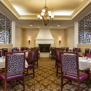 Elegant dining room with a classic interior design featuring chandeliers and ornate chairs.