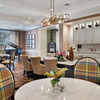 A modern and elegant living space featuring a dining area with a grand piano, stylish chandelier, and vibrant decor.