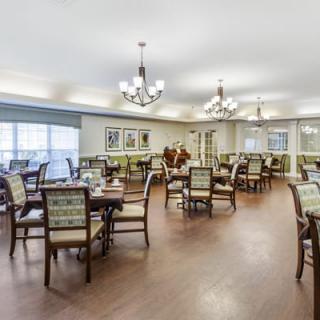 An elegantly furnished dining area with multiple tables and chandeliers.