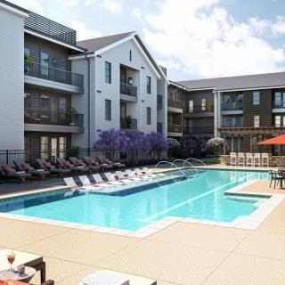 A modern apartment complex with an inviting outdoor swimming pool surrounded by lounge chairs on a sunny day.