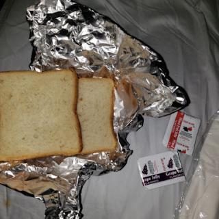 A simple snack consisting of two slices of bread wrapped in aluminum foil.