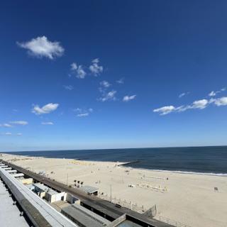 A serene view of a beach under a bright blue sky.