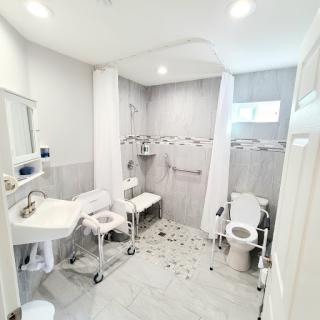 A spacious and accessible bathroom equipped with modern amenities including a shower, sink, and toilet.