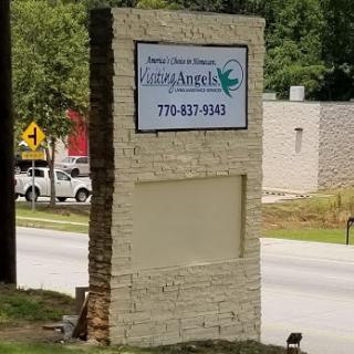 A sign displaying the name and contact information of a business.
