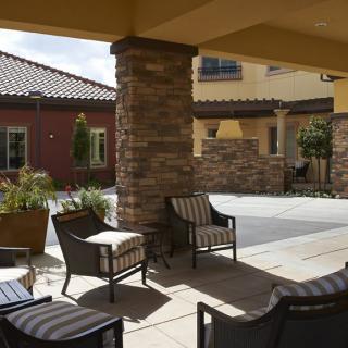 A cozy outdoor patio area with comfortable seating and architectural features.