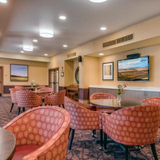 A cozy lounge with comfortable seating and artwork on the walls.