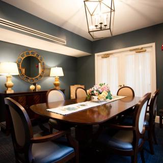 Elegant dining room with a wooden table, upholstered chairs, and decorative elements.