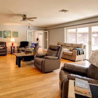 A spacious living room with comfortable seating and large windows allowing natural light.