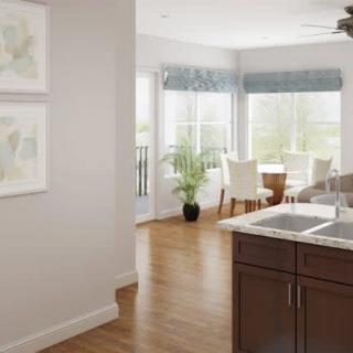 A modern kitchen and dining area with ample natural light and wooden flooring.