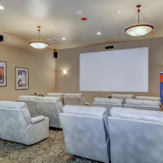 A cozy home theater setup featuring plush seating and a large projector screen, perfect for movie nights.