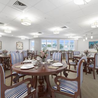 Elegant dining room with neatly arranged tables and striped chairs.