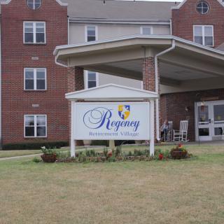 Entrance to a building with a sign that reads 'Regency' in front.