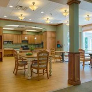 A modern kitchen and dining area with wooden floors and warm lighting.