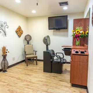 A modern hair salon interior featuring comfortable seating and decorative elements.