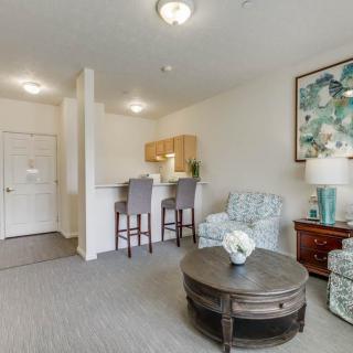 A cozy living space with an open kitchen and comfortable seating area featuring stylish decor.