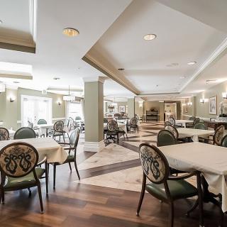 A spacious and elegantly designed dining area with neatly arranged tables and chairs.