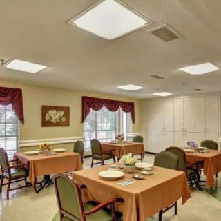 A cozy dining room with neatly set tables and warm lighting.