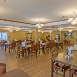 Spacious dining area with neatly arranged tables and chairs under elegant lighting.