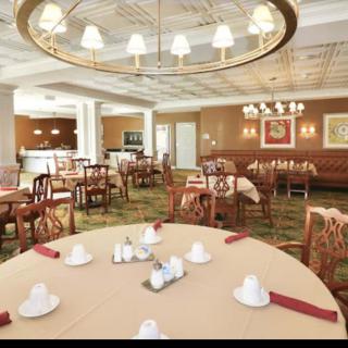 Elegant restaurant dining area with neatly set tables and stylish chandeliers.