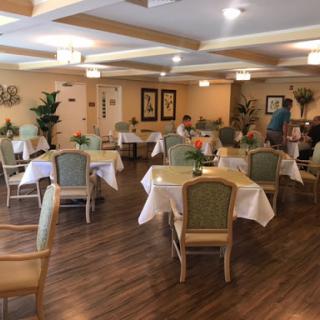 A cozy dining area with elegantly set tables and comfortable chairs, inviting guests to enjoy a meal.