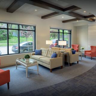 A modern waiting room with comfortable seating and large windows.