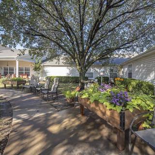A serene outdoor garden area with seating and lush greenery.