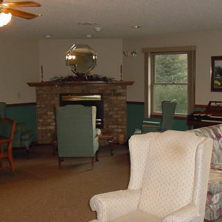 A cozy living room with a fireplace and various seating options.