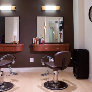 A well-organized hair salon with two styling stations featuring comfortable chairs and mirrors.