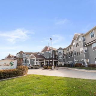 A large residential building with a well-maintained lawn and clear blue sky.