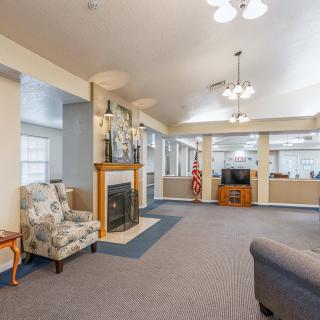 A spacious living room with a fireplace, seating area, and television.