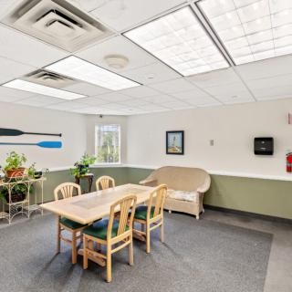 A well-lit meeting room with a table, chairs, and indoor plants.