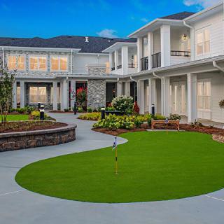 A modern luxury house with well-maintained landscaping and a spacious outdoor area.