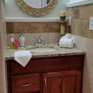 A stylish bathroom vanity with a mirror, sink, and neatly arranged toiletries.