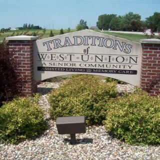 Entrance sign for Traditions of West Union surrounded by landscaping.