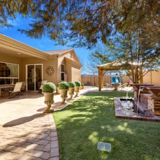 A serene backyard space featuring well-maintained greenery and a cozy seating area.