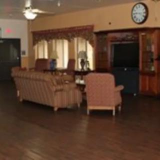 A living room with sofas, a television, and wood flooring.
