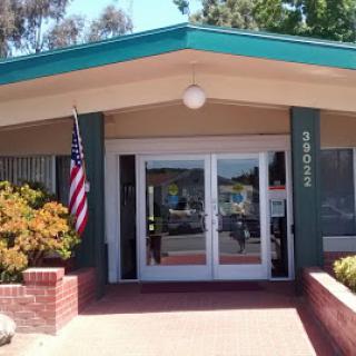 A welcoming entrance featuring an American flag and well-maintained landscaping.