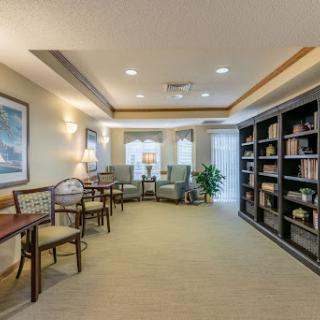 A cozy and well-lit lounge area featuring comfortable seating and bookshelves, perfect for reading or relaxation.