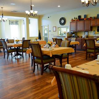 A well-arranged dining area with neatly set tables and chairs in a cozy indoor setting.