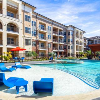 Modern apartment complex with a luxurious outdoor pool area.