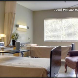 A semi-private hospital room with two beds and a window.