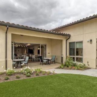 A modern house with a spacious patio and well-maintained backyard garden.