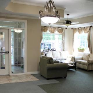 A cozy living room with comfortable seating, elegant chandelier, and ample natural light.