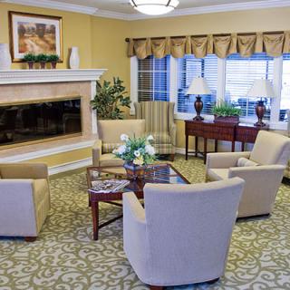 A cozy living room with elegant furniture and a fireplace, featuring a well-arranged seating area.
